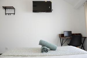 a bedroom with a bed with a television on the wall at Train Station Guesthouse in Faro