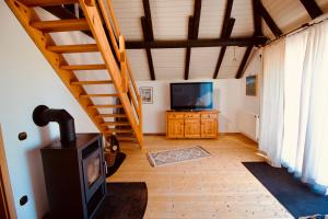 a living room with a wood stove and a television at Ferienhaus Norderwieke in Großefehn 