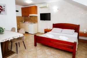 a bedroom with a bed and a table and a kitchen at Apartments Ivana in Tivat