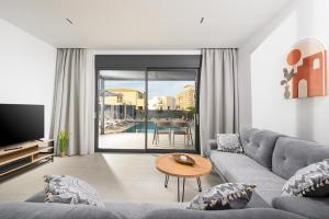 a living room with a couch and a table at Petrus Luxury Villas in Old Hersonissos - 3 Bedrooms & 3 Bathrooms in Hersonissos