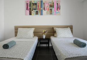 two beds sitting next to each other in a room at Train Station Guesthouse in Faro