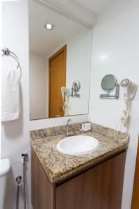a bathroom with a sink and a mirror at Sofisticado Flat em Brasília-BR in Brasilia
