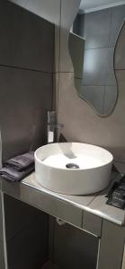 a white sink in a bathroom with a mirror at Georgia apartments in Stafylos +40 photos