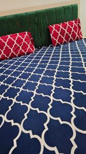 a couch with a blue and white patterned carpet at Executive Inn Guest House in Karachi