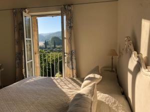 ein Schlafzimmer mit einem Bett und einem großen Fenster in der Unterkunft PETIT MIRACLE, Oppède in Oppède + 79 Fotos