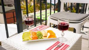 a plate of food on a table with two glasses of wine at Anzede Konaklama Çeşme in Çeşme