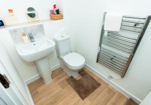 a bathroom with a white toilet and a sink at Nay Apartment Two-Bedroom Appt in Coventry in Longford +10 photos