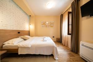 a bedroom with a white bed and a wall at Villa Adria in Kotor