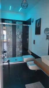 een badkamer met 2 toiletten en een glazen douche bij Appartamenti Addimuru in Marina di Palma