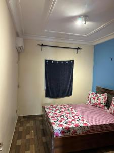a small bedroom with a bed and a window at Tapoko residence in Yaoundé +2 photos