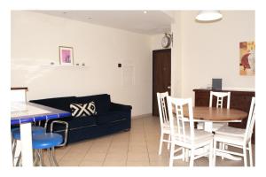 een woonkamer met een bank, een tafel en stoelen bij Fiamme Gialle in Lido di Ostia +3 foto's