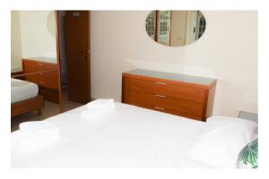 een slaapkamer met twee bedden, een ladekast en een spiegel bij Fiamme Gialle in Lido di Ostia