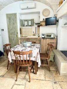 a kitchen with a table and chairs in a kitchen at La Casetta - Typical Guest House in Fasano +10 photos
