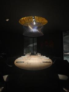 een tafel met glazen en een kroonluchter in een kamer bij Mondschein Hotel & Chalet Ski-In Ski-Out Luxus am Arlberg in Stuben am Arlberg