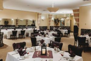 a dining room with white tables and chairs at Somerset Inn, WorldHotels Distinctive in Troy