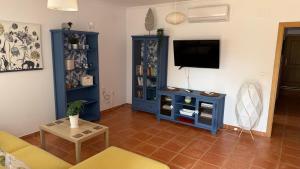 a living room with a blue cabinet and a tv at La Casa Azul in Isla Canela