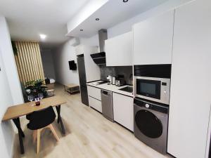 een keuken met witte kasten en een houten tafel bij Apartamento Río Turia C in Valencia +3 foto's