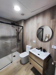 een badkamer met een toilet, een wastafel en een spiegel bij Apartamento Río Turia C in Valencia