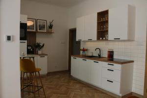 Una cocina con gabinetes blancos y un fregadero y una mesa. en Timeless apartment near city center, en Staré Mesto 29 fotos más