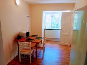 a dining room with a table with chairs and a microwave at Ekebo Guesthouse in Svalöv