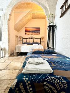 a bedroom with two beds and a painting on the wall at La Casetta - Typical Guest House in Fasano