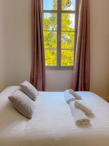 ein Bett mit zwei Handtüchern und einem Fenster in der Unterkunft Le Rosy By ApiRent #Balcon #Wifi #Centre-ville in Cannes