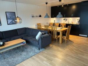 a living room with a couch and a table and a kitchen at Apartment Øvre Tråstølen - Voss in Vossevangen