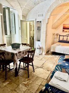 a room with a table and chairs and a bed at La Casetta - Typical Guest House in Fasano