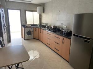 a kitchen with a stainless steel refrigerator and a dishwasher at Appartement spatieux in Tangier +5 photos