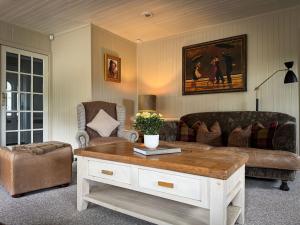 a living room with a couch and a coffee table at Stunning country home with private wellness Spa in Strachur