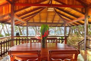 a wooden table with a vase of flowers on it at Pieza Paraíso in Cabo Matapalo