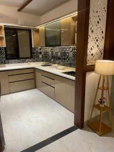 a kitchen with white cabinets and a table and a stool at The Divine Villa ! in Indore