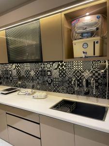 a kitchen with black and white tile on the wall at The Divine Villa ! in Indore +11 photos