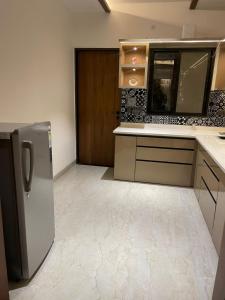 a kitchen with a stainless steel refrigerator and cabinets at The Divine Villa ! in Indore