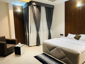 a bedroom with a bed and a chair and a window at The Divine Villa ! in Indore