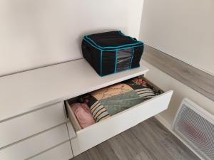 a small closet with a white shelf and a suitcase at Studio meublé centre ville- gare Villers Cotterets in Villers-Cotterêts