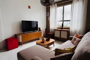 a living room with a couch and a flat screen tv at Apto 2 quartos - Encanto de Belém in Curro Velho