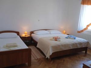 a bedroom with two beds with towels on them at Apartmani Vesna in Lun