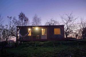 ein kleines Haus mit Hängematte auf einem Feld in der Unterkunft Daisy-a romantic logcabin hiding amongst the trees in Stoke Canon + 24 Fotos