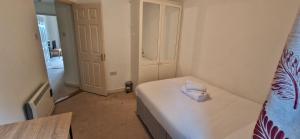 a small bedroom with a bed with a white sheets at Tidy Spacious & Quiet 2BD on Edge of Cork City in Cork
