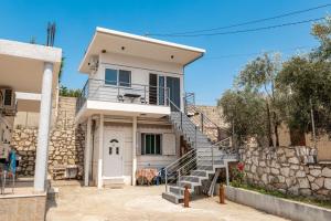 a white house with a staircase in front of it at Vila Celi in Sarandë