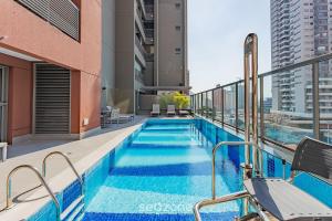 a swimming pool on the roof of a building at HMO - Estúdios completos em prédio c/ piscina in Sao Paulo