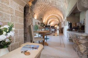 a room with a stone archway with a table and chairs at Masseria Pizzofalcone in Supersano
