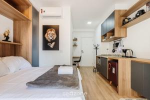 a bedroom with a king sized bed and a kitchen at HMO - Estúdios completos em prédio c/ piscina in Sao Paulo