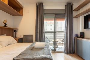 a bedroom with a bed and a balcony at HMO - Estúdios completos em prédio c/ piscina in Sao Paulo +32 photos