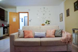 a couch with pillows on it in a living room at House 416 Sweet Apartment in Perugia