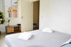 una camera da letto con un letto bianco con due asciugamani sopra di Ostia Holiday Kama 2 a Lido di Ostia