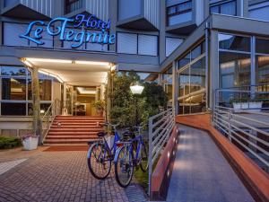 dos bicicletas estacionadas frente a un edificio en Hotel Le Tegnue en Sottomarina