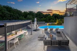 un patio con tavoli e sedie accanto a una piscina di Vila Lux 2 a Fiume (Rijeka)