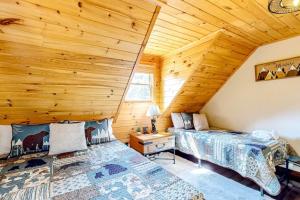 a bedroom with two beds in a log cabin at Grandpa John Cabin - Hot Tub, Game Room in Sugar Grove